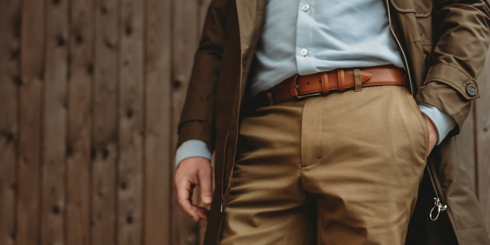Ruskea, laadukas vyö miehen beigeissä housuissa.