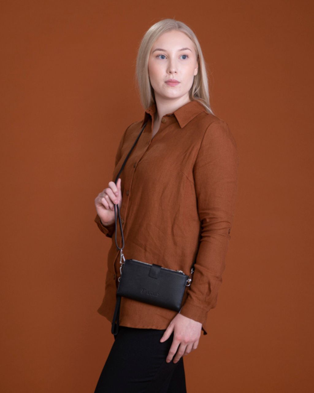 Keltainen nahkainen puhelinlompakko olkahihnalla