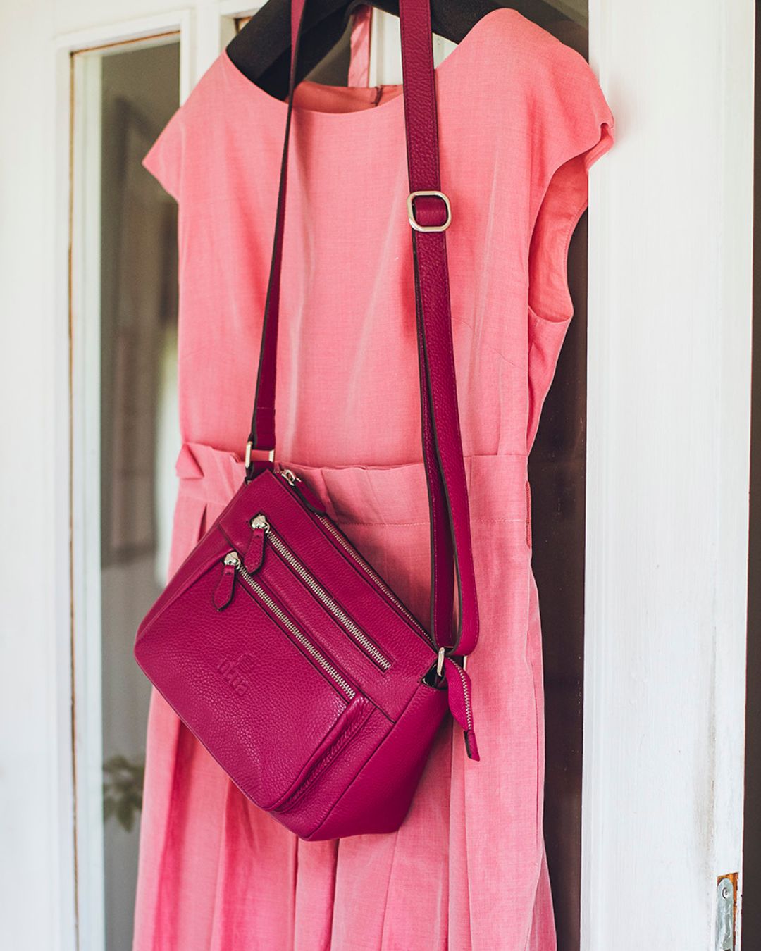 utua hestia daalianpunainen hestia olkalaukku ovessa