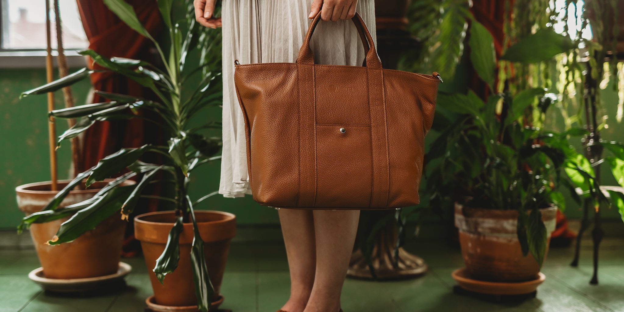 Ruskea työlaukku vihreässä ympäristössä.